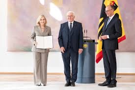 Nina Warken receiving a certificate of appointment from Federal President Frank-Walter Steinmeier, with Chancellor Friedrich Merz beside them