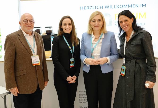 Nina Warken talking with three people at an event stand marked Forum