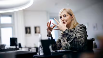 Nina Warken seated at a desk in an office, gesturing as she speaks