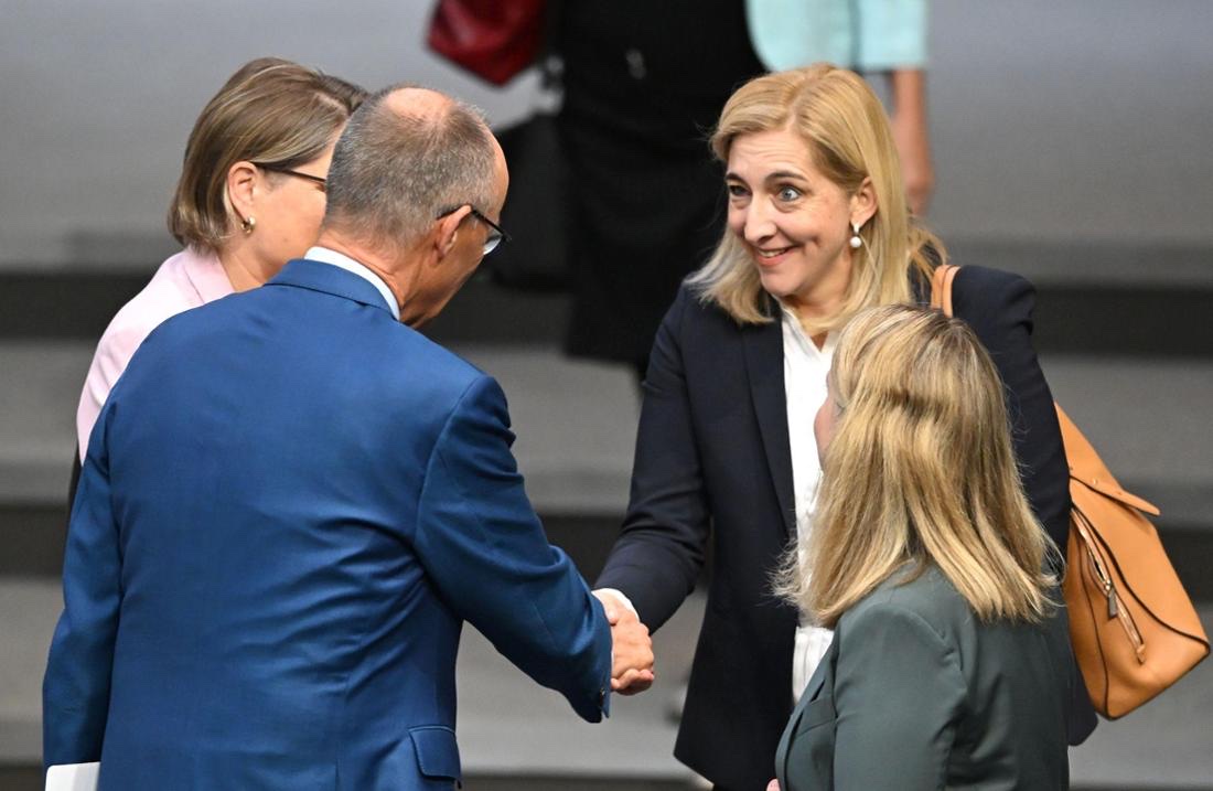Nina Warken shaking hands with Chancellor Friedrich Merz in the Bundestag plenary chamber